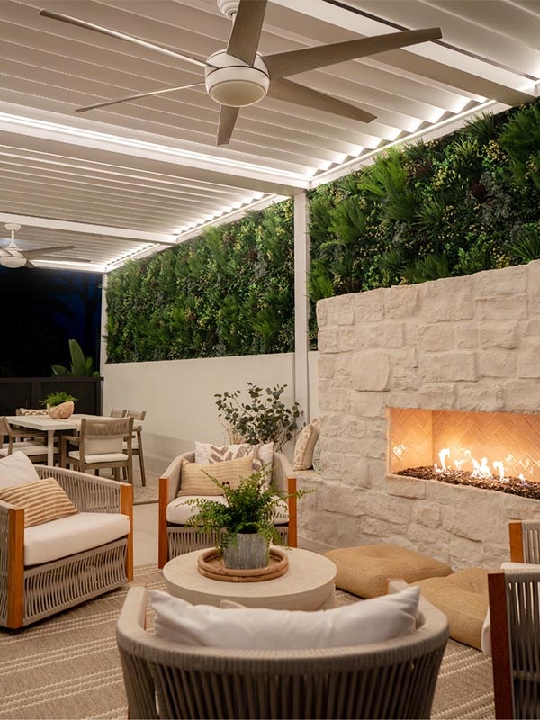 Outdoor lounge with living wall, fireplace, and pergola